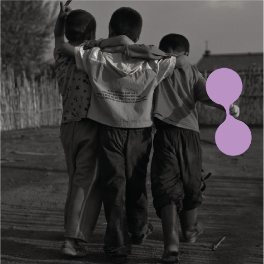 Three children walking with arms around each other, one flashing a peace sign. A soft purple re:you shape floats nearby. Friendship, innocence, and connection—before the world asks us to be someone.